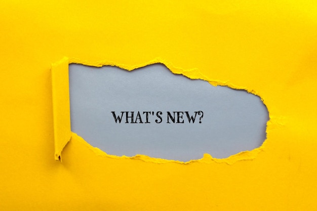 Was ist der neue Fragebuch auf gerissenem gelbem Papier mit grauem Hintergrund? Konzeptuelles Foto
