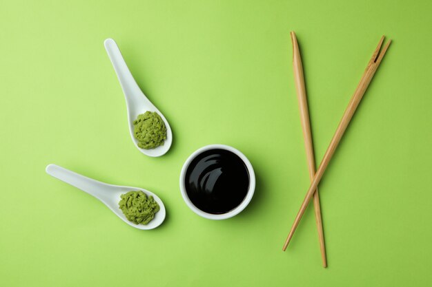 Wasabi, molho de soja e pauzinhos no verde