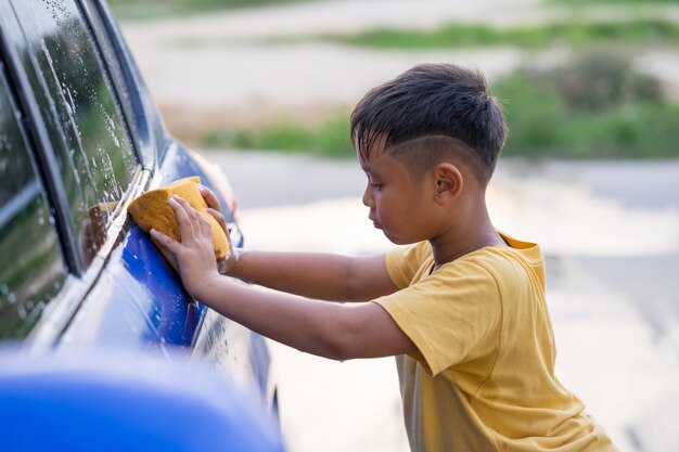 Waschendes Auto des asiatischen Kinderjungen