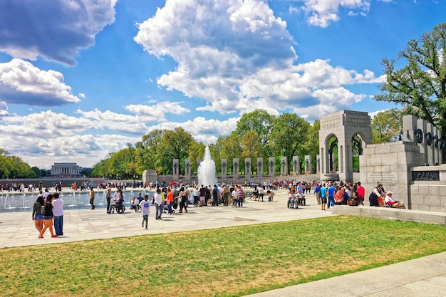 Washington DC, EE.UU. - 2 de mayo de 2015: Turistas y veteranos de guerra y guardianes de la organización sin fines de lucro Honor Flight en National World War 2 Memorial, National Mall. Arco Atlántico a la derecha