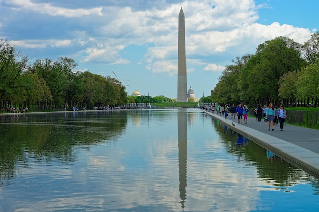 Washington DC, Estados Unidos - 2 de mayo de 2015: La gente está dando un paseo cerca de la piscina en el National Mall, Washington DC El monumento del primer presidente estadounidense George Washington se ve en la parte de atrás.