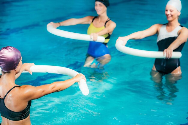 Foto wasser-aerobics-klasse gruppe von frauen trainiert mit einem ausbilder