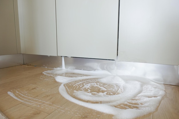 Wasser aus einer Geschirrspülmaschine auf dem Küchenboden