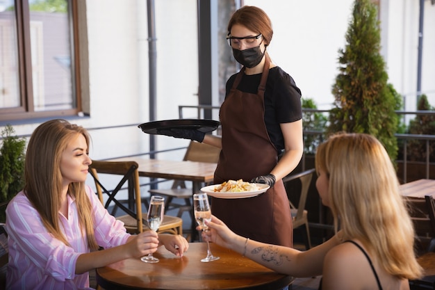 Wasser, das mit Gesichtsmaske im Restaurant arbeitet, Ausbruch des Coronavirus