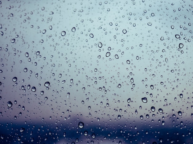 Wasser fällt auf Fensterglas mit Stimmung und Ton des regnerischen Tages.