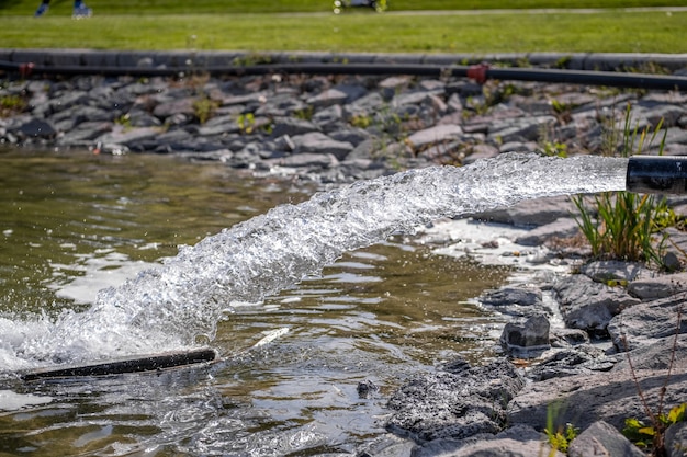 Wasser fließt aus einem Metallrohr in einem öffentlichen Park