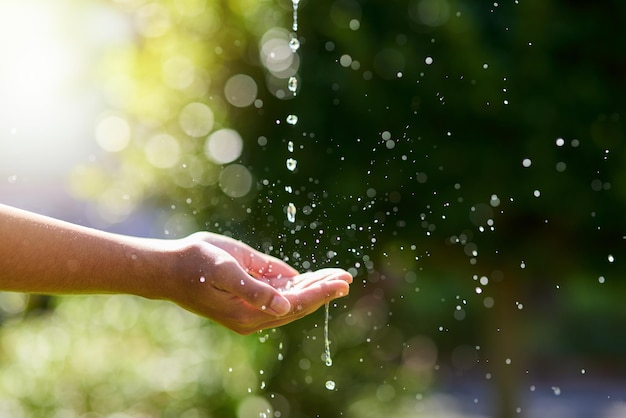 Wasser ist Leben Aufnahme von Händen, die ausgestreckt sind, um draußen einen Wasserstrahl aufzufangen