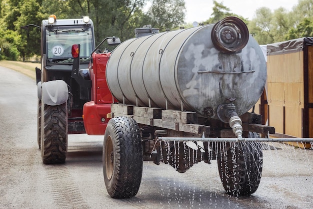 Wasser-LKW-Sprinkler-Tank besprüht Straße gegen Staub. Schwerer LKW gießt Straße mit Wasser