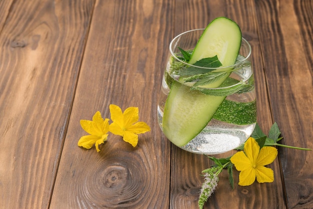 Wasser mit frischer Gurke und Pfefferminze in einem Glas auf rustikalem Hintergrund