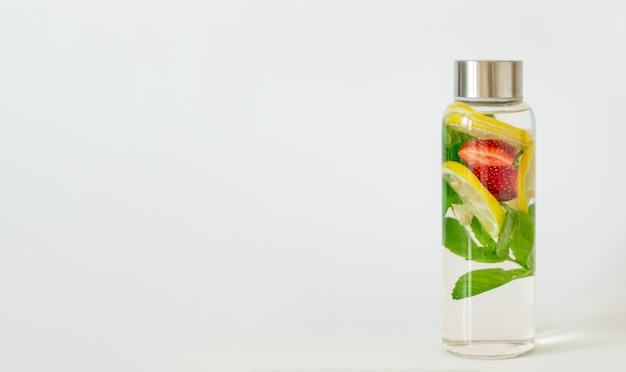 Wasser mit Zitronen-, Erdbeer- und Minzgeschmack. Erfrischungsgetränk für den Sommer. Gesundheitswesen, Fitness, gesunde Ernährung Diät-Detox-Konzept. Weißer Hintergrund, Kopienraum.