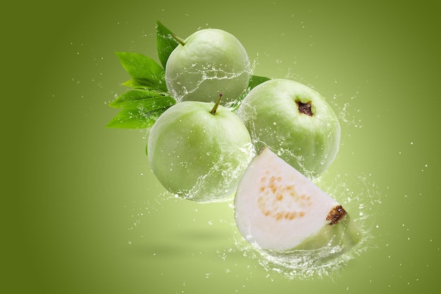 Wasser spritzt auf Guava-Frucht isoliert auf grünem Hintergrund