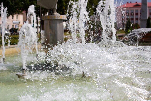 Foto wasser spritzt im brunnen vor dem hintergrund der stadt