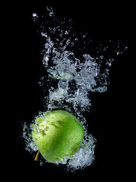 Wasser spritzt mit grünem Apfel.