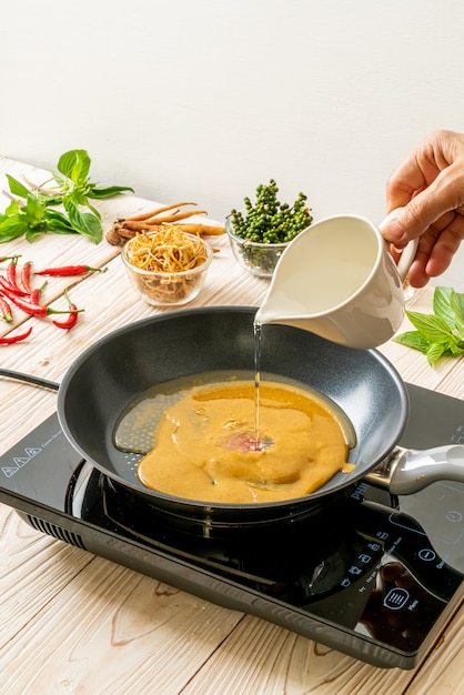 Wasser und Sauce auf die Pfanne gießen