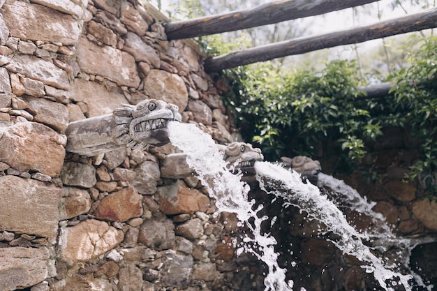 Foto wasserbrunnen, der aus einer ziegelsteinmauer kommt