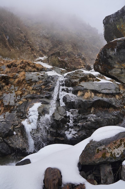 Wasserfall in schneebedeckten Hügeln