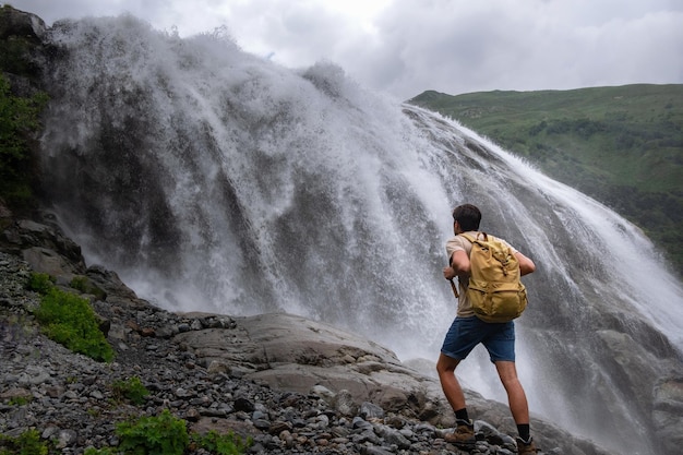 Wasserfalllandschaft und männlicher Reisender, der Blick auf den Wasserfall genießt