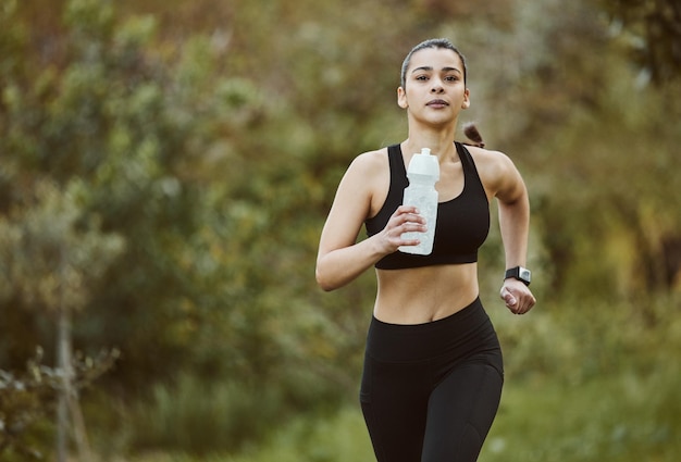 Wasserflasche für Frauen und Laufen in der Natur für Fitnesstraining oder Outdoor-Übungen mit Flüssigkeitszufuhr. Aktive Sportlerin oder Läuferin und natürliches Mineralgetränk für das Training von Ernährung oder Nachhaltigkeit