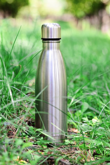 Wasserflasche Wiederverwendbare Thermo-Wasserflasche aus Stahl auf grünem Gras