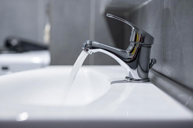 Wasserhahn Wasserhahn Fließwasser im Badezimmer mit Waschbecken Modernes, sauberes Haus Hygienekonzept