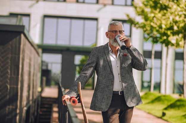 Wasserhaushalt. Ein Mann in einer eleganten Jacke mit einer Flasche in der Hand