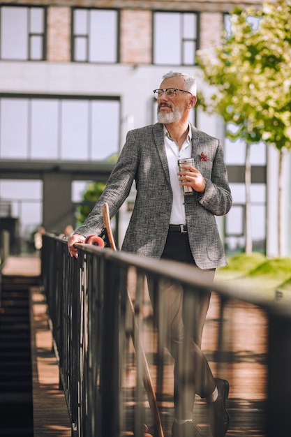 Wasserhaushalt. Ein Mann in einer eleganten Jacke mit einer Flasche in der Hand