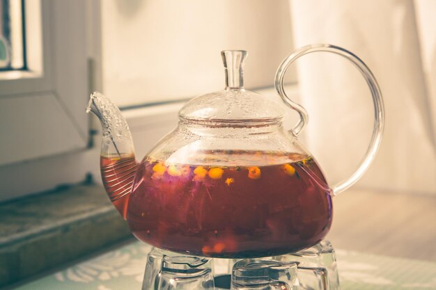 Wasserkocher mit rotem Tee mit Beeren und Kräutern