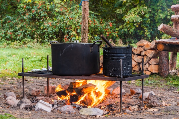 Wasserkocher über Lagerfeuer. Essen in freier Wildbahn kochen. Camping-, Reise- und Tourismuskonzept