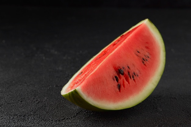 Wassermelone auf schwarzem Hintergrund in Scheiben geschnittene Früchte mit Samen