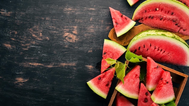 Wassermelone in einer Holzkiste In Stücke geschnittene Wassermelone Auf einem hölzernen Hintergrund Freier Platz für Text Ansicht von oben