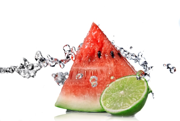 Foto wassermelone, limette und wasserspritzer isoliert auf weiß