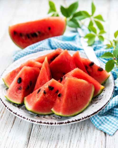 Wassermelone mit grünen Blättern auf einem alten Holztisch