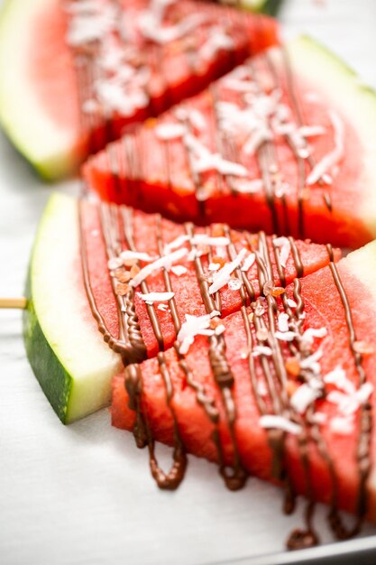 Wassermelone mit Schokolade beträufelt und mit Meersalzflocken und Kokosnuss garniert.