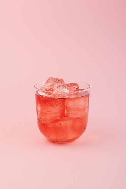 Wassermelonen-Erfrischungsgetränk Rotes alkoholfreies Sommergetränk mit Eis Frucht-Eistee auf rosa Hintergrund