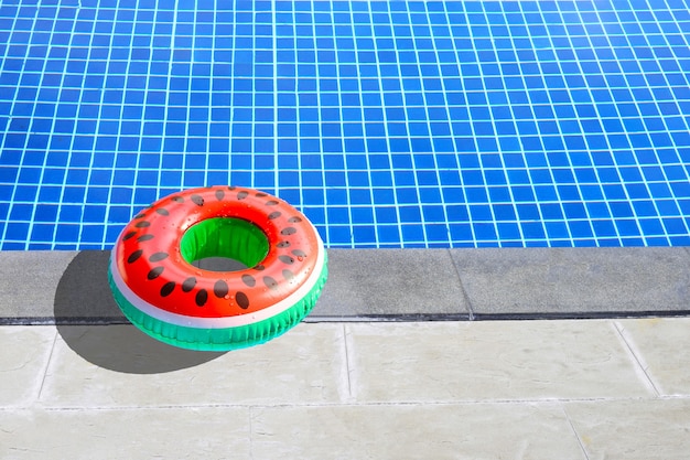 Wassermelonen-Gummiring zum Schwimmen auf dem Betonboden des Schwimmbeckens. Sommerhintergrundkonzept