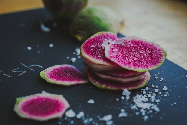 Wassermelonen-Radieschen in Scheiben geschnitten, mit Meersalz bestreut