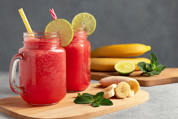 Wassermelonen-Smoothie mit Banane, Limette und Minze in Bechergläsern