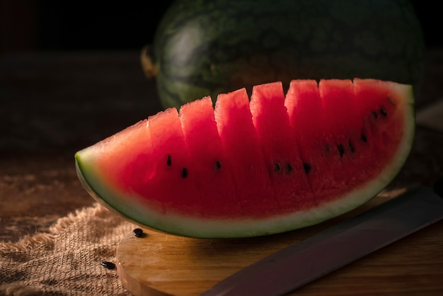 Wassermelonen- und Wassermelonenstücke in einem hölzernen Hintergrund