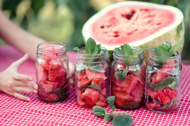 Foto wassermelonenlimonade mit eis und minze als sommerliches erfrischungsgetränk in gläsern.