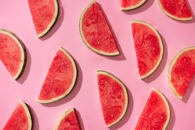 Wassermelonenmuster. Geschnittene Wassermelone auf weißem Hintergrund. Flache Lage, Ansicht von oben