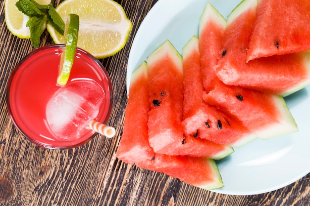 Wassermelonensaft aus reifem rotem und saftigem Wassermelonensaft ist ein natürliches gesundes und diätetisches Produkt. Wassermelonensaft wird in einen Glasbehälter gegossen