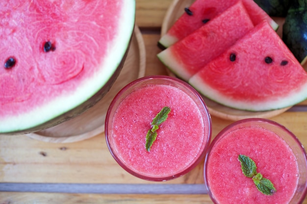 Wassermelonensaft in ein Glas und in Scheiben geschnittene Wassermelone gemischt