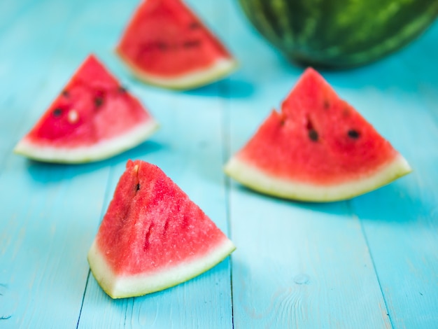 Wassermelonenscheiben auf blauer hölzerner Tischplatte