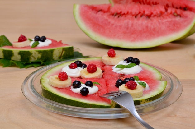 Wassermelonenscheiben in Form eines Kuchens auf einer Platte in der Nähe