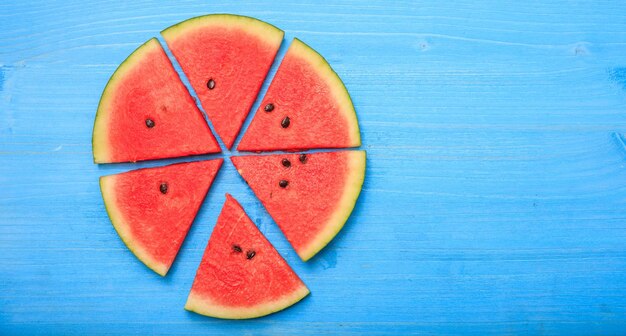 Foto wassermelonenstücke auf einem blauen tisch