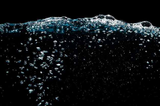 Foto wasseroberfläche mit wellen und blasen schwimmen auf schwarzem hintergrund