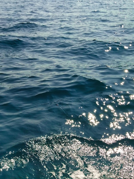 Wasseroberfläche mit Wellen und Sonnenstrahlen am Sommertag