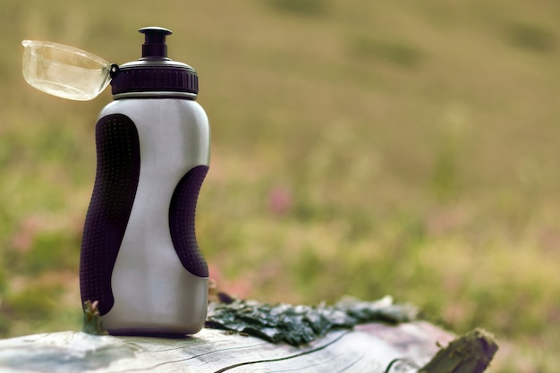 Wassersportflasche, die von Outdoor-Menschen wie Kletterern, Wanderern und Campern auf Naturhintergrund verwendet wird.