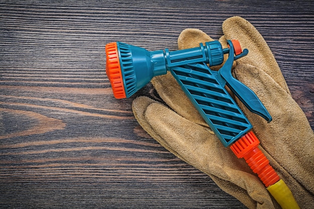 Wassersprinkler-Schutzhandschuhe auf Holzbrett-Landwirtschaftskonzept