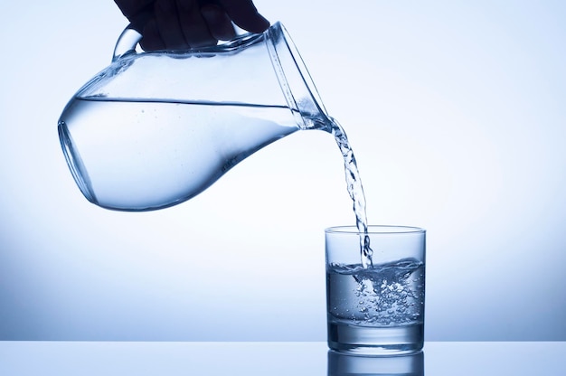 Wasserspritzer aus einem Krug in ein Glas